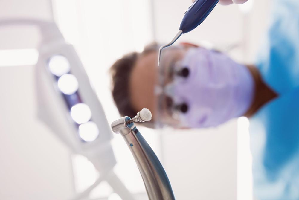 dentist-holding-dental-tools-scaled